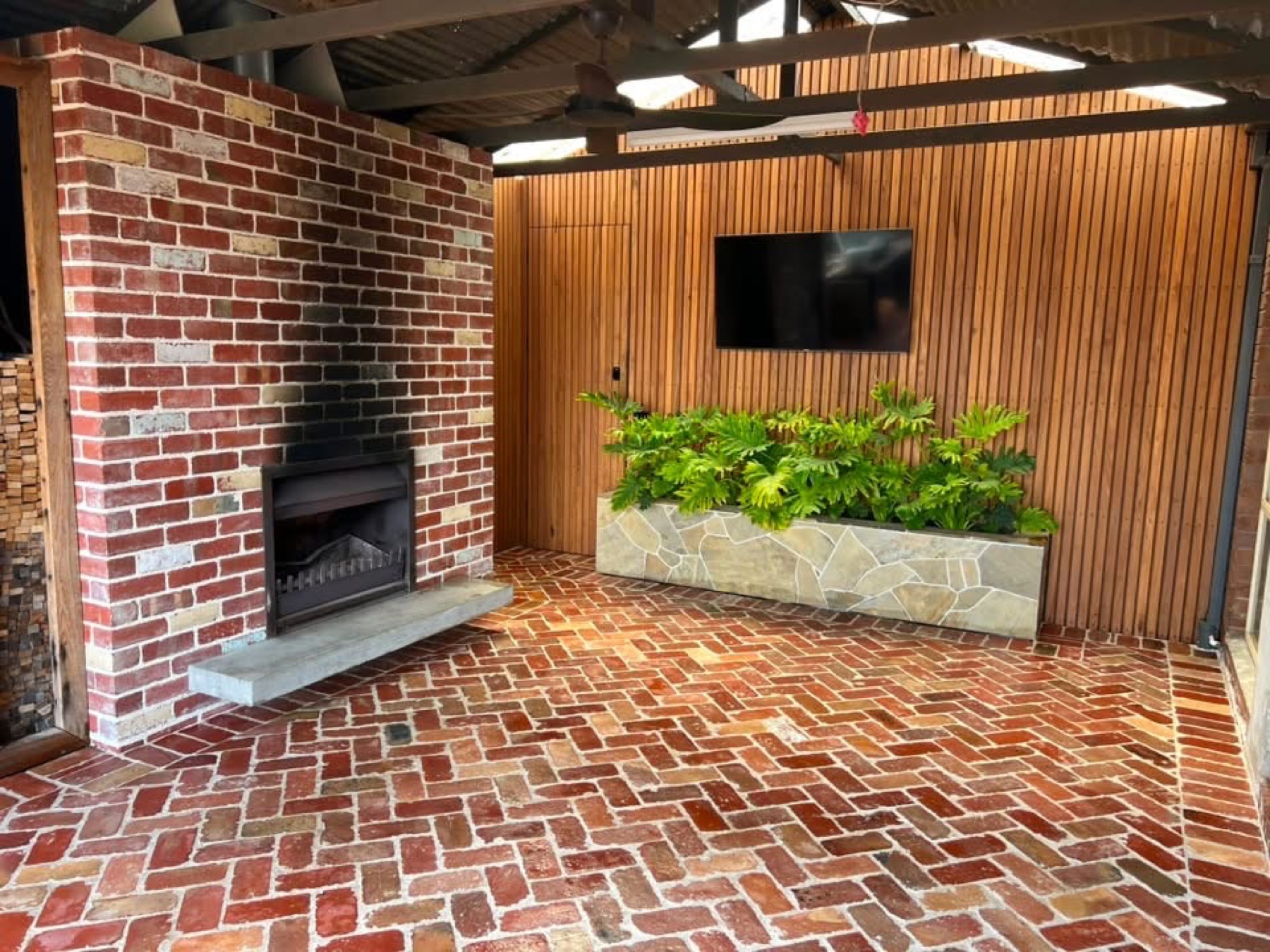 Undercover alfresco with fireplace and brick paving